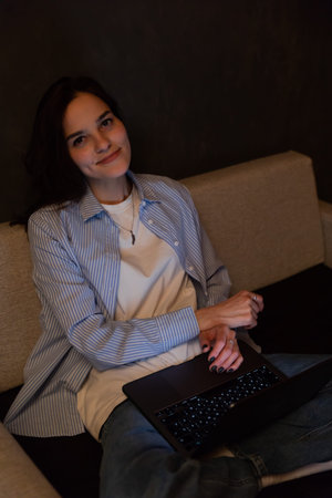 woman with laptop in dark room at remote work internet communication IT work