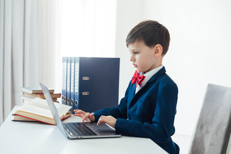 Little boy using laptop on white backgroundの写真素材
