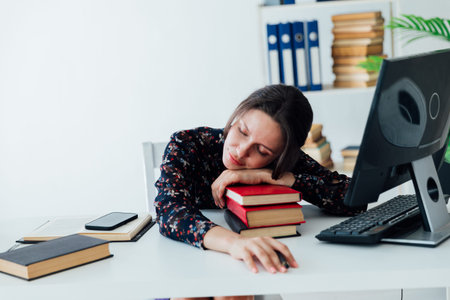 Woman lying on books in office in office business woman training educationの写真素材