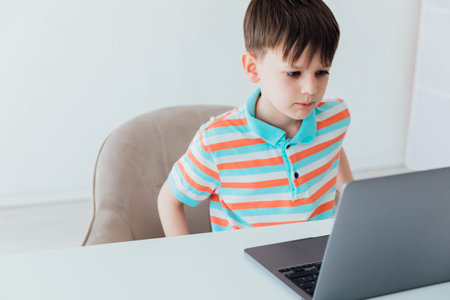 Boy doing learning task at school on computer