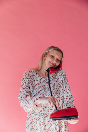 Beautiful woman talking on retro wired phoneの写真素材