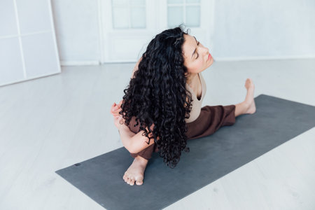 Fit healthy young woman doing pilates yoga exercise fitness training workout at home interiorの写真素材