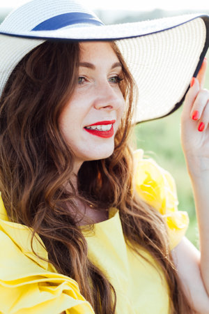Portrait of a beautiful woman in a hat in natureの写真素材