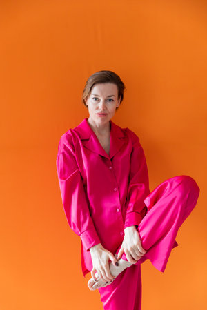 Beautiful fashionable woman in crimson silk pajamasの写真素材