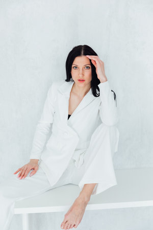 Beautiful fashionable brunette woman in white business suitの写真素材