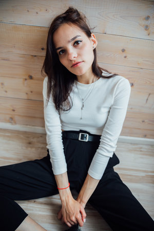 Beautiful slender young woman sitting on the floorの写真素材