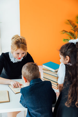 Female teacher teaching children in school classroomの写真素材