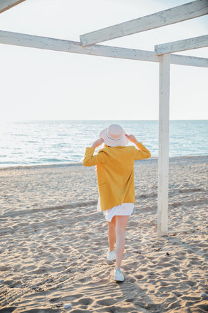 beautiful blonde woman walking on the beach by the seaの写真素材
