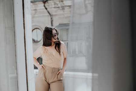 Woman in beige clothes on the balcony in the roomの写真素材