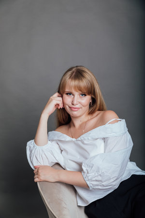 Beautiful red-haired woman posing on gray backgroundの写真素材