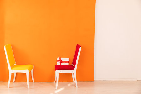 yellow and red chairs with a gift on an orange interiorの写真素材