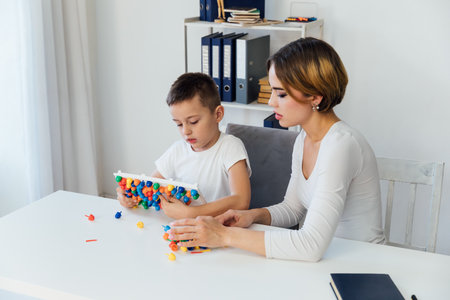 Woman playing with boy in educational educational games at schoolの写真素材