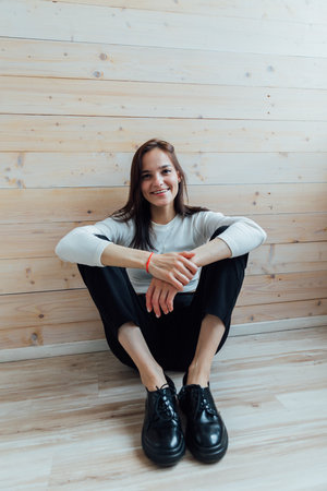 Beautiful slender young woman sitting on the floorの写真素材