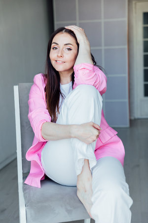 Portrait of a beautiful brunette woman in white clothes and pink jacketの写真素材