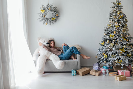 Beautiful woman at christmas tree with gifts for new yearの写真素材