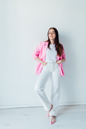 Beautiful brunette woman in white suit and pink jacketの写真素材