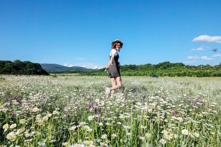 woman in the field with flowers daisies outdoor recreation walk hikeの写真素材