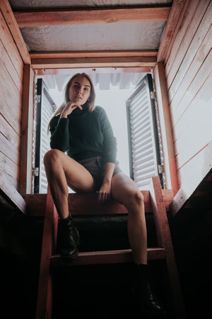 beautiful blonde woman on the stairs of the house in the atticの写真素材