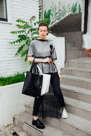 Slender fashionable woman walking outdoorsの写真素材