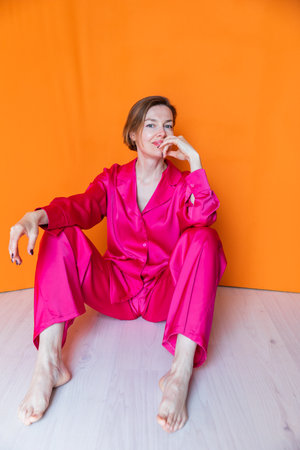 Beautiful slender woman in pink silk pajamasの写真素材