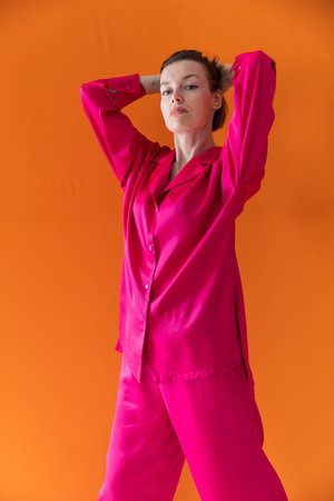 Beautiful slender woman in pink silk pajamasの写真素材