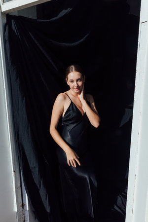 Beautiful fashionable slender woman in black silk evening dressの写真素材