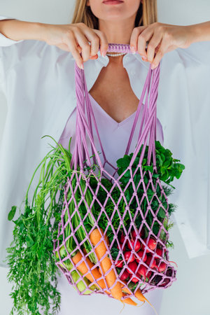 Woman With Bag Mesh Fresh Vegetables For Eating Dietの写真素材