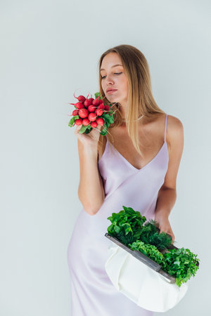 Female nutritionist holding bag with vegetables for eatingの写真素材