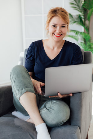 Beautiful woman working online on computer at homeの写真素材