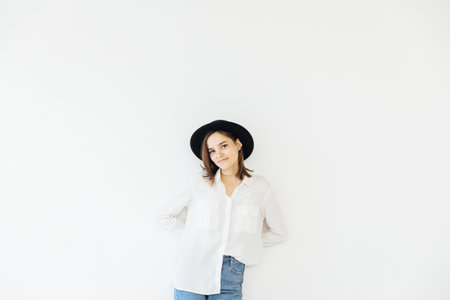 Woman in hat posing in bright studioの写真素材