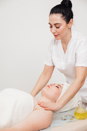 A woman beautician massages the shoulders of a clientの写真素材