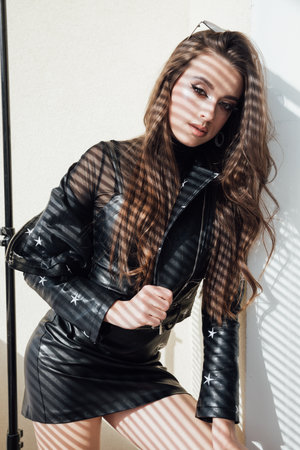 Shadow from blinds on beautiful fashionable womanの写真素材