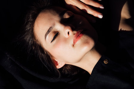 Beautiful slender woman in black lingerie in bedroom on bedの写真素材