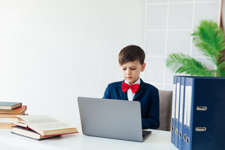 Little boy using laptop on white backgroundの写真素材