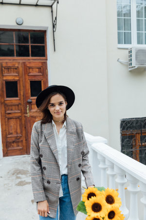 Beautiful brunette woman in hat walking in autumn cityの写真素材