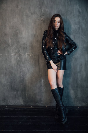 Portrait of fashionable young woman in dark stylish clothesの写真素材