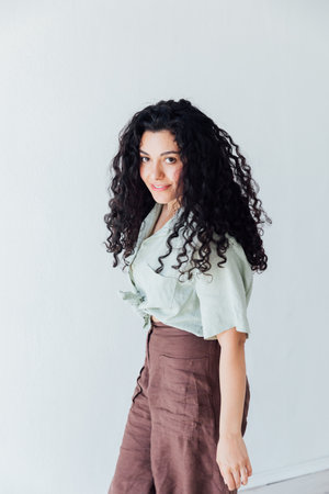 Portrait of a beautiful fashionable woman with black curly hairの写真素材