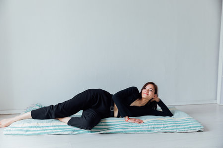 Beautiful woman lying on sleeping mattress on the floorの写真素材