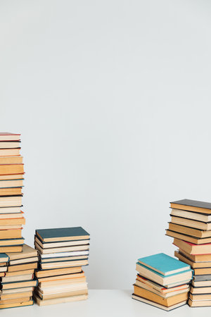 Lots of stacks of educational books on white school university library backgroundの写真素材