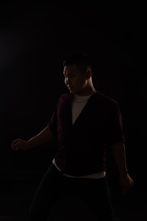 A man dancing in the dark in a studioの写真素材