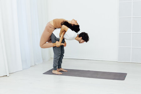 Yoga group concept. Young couple meditating together, sitting back to backの写真素材