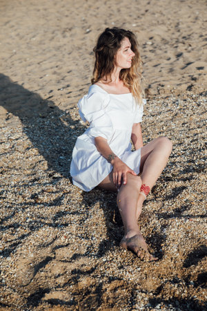 Portrait of a beautiful smiling woman in a summer light dressの写真素材
