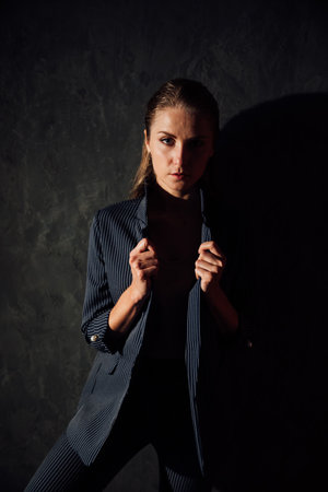Portrait of a beautiful young slender blonde woman in a gray business suitの写真素材