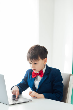 Business boy in jacket sitting at laptopの写真素材