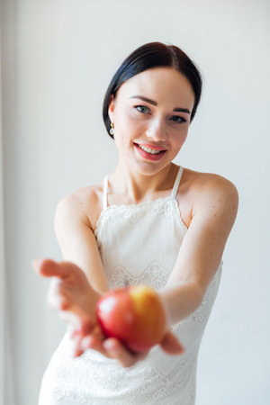 Beautiful brunette woman and ripe apple for eatingの写真素材