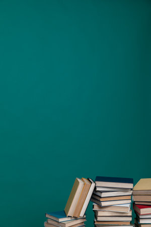A simple composition of many books, stack or pile of books on wooden table, one of them open with copy space.の写真素材