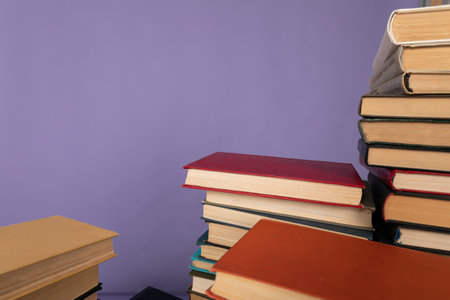 Lots of stacks of educational books for library on purple backgroundの写真素材