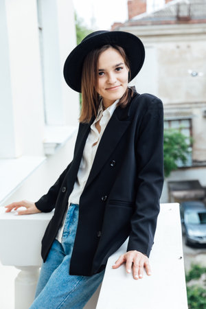 Woman in a hat on the balcony in the apartmentの写真素材