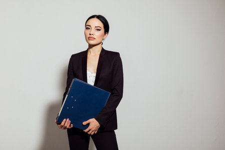 Woman in business suit with folders in office spaceの写真素材