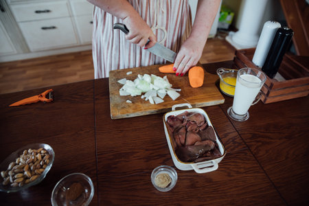 Female housewife in kitchen cooking food from vegetablesの写真素材